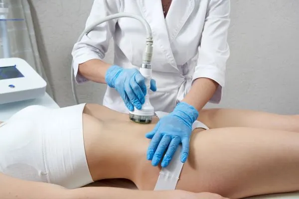 Lost the Weight but Not the Loose Skin? 2 woman having HIFU treatment on her stomach to combat loose skin Byfleet following weight loss